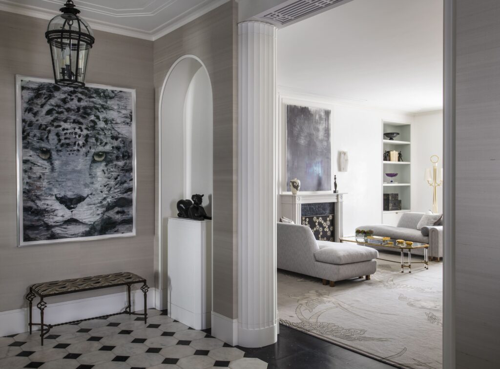 Elegant living room with leopard artwork, modern gray sofas, and a stylish fireplace, featuring geometric flooring.