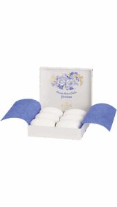A white box with blue accents contains six white gardenia soaps, elegantly presented.