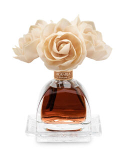 A glass bottle of Agraria Balsam fragrance topped with cream-colored rose decorations.