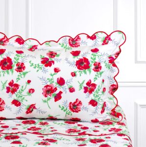 Floral bedding featuring red poppies and green leaves with scalloped edges.