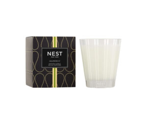 A grapefruit-scented candle next to its decorative black box.