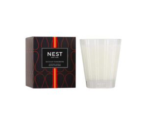 Scented candle in a clear glass holder next to its black and red box labeled "Sicilian Tangerine.
