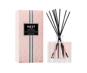 Reed diffuser with black sticks beside a pink box labeled "Himalayan Salt & Rosewater.