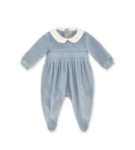 Light blue baby romper with a white collar and smocked detailing, featuring long sleeves and footed design.