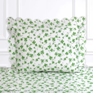 White bedding with green clover patterns and scalloped edges, featuring a matching pillowcase.