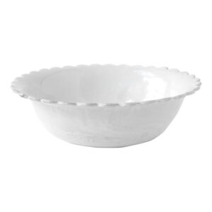 White salad bowl with a scalloped edge, empty and reflecting light.