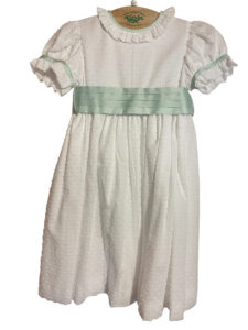 White dress with puffed sleeves and a mint green sash, featuring a textured pattern.