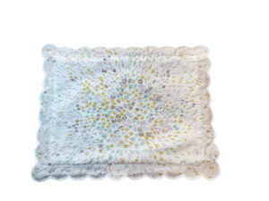 Floral-patterned fabric in celadon and yellow with scalloped edges, featuring scattered blossoms and leaves.