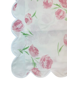 Scalloped edge sheet featuring pink roses and green leaves on a white background.