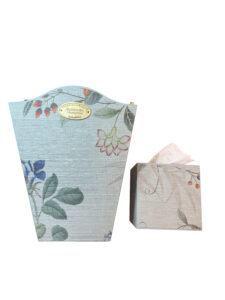 Curved-edge wastebasket and tissue box in Chinoiserie grass cloth with floral patterns.