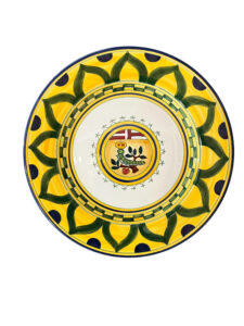 Colorful ceramic plate featuring a central design with a plant and fruit motif, surrounded by yellow and green patterns.