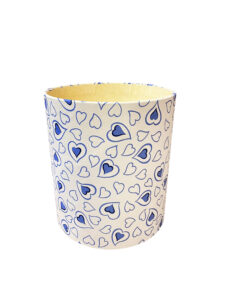 A decorative wastebasket featuring blue hearts on a white background.
