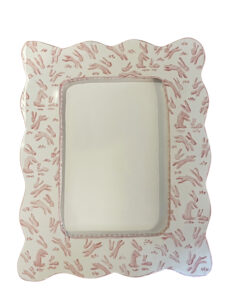 A decorative picture frame with a scalloped edge and pink bunny patterns.