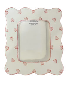 A scalloped picture frame decorated with pink hearts, featuring a slot for photo insertion at the back.