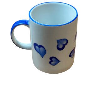 Ceramic mug with blue heart designs and a blue rim.
