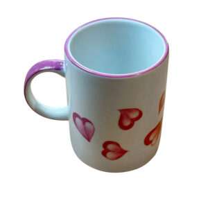 Ceramic mug with a pink handle and heart designs in various shades of red.
