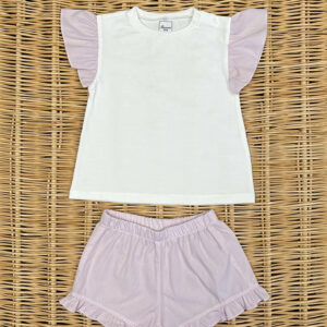 A white shirt with pink ruffled sleeves paired with matching pink shorts on a woven surface.