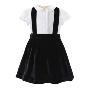 Black velvet dress with white collared shirt and suspenders, featuring a pleated skirt.