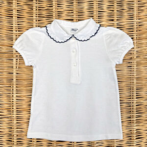White short-sleeve polo shirt with a ruffled collar and three buttons, laid flat on a woven surface.