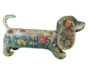 A decorative silk velvet dachshund with colorful floral embroidery.