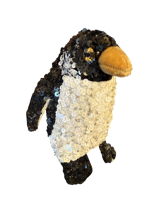 Small penguin plush covered in black and white sequins, with a soft orange beak and shiny eyes.