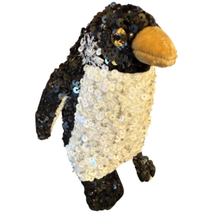 Small penguin plush covered in black and white sequins, with a soft orange beak and shiny eyes.