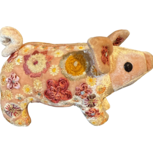 A plush piglet in old rose velvet, adorned with colorful floral embroidery.
