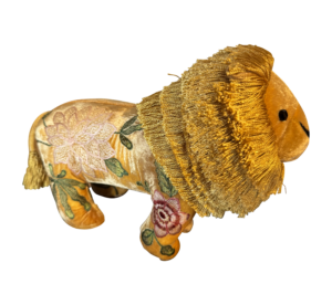 A plush lion with a golden mane and floral embroidery on its body.