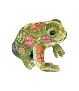 A green velvet frog with floral embroidery sits on a black background.