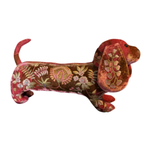 A pink silk velvet dachshund with floral embroidery stands upright.