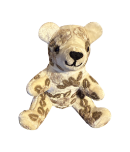 Ivory velvet bear with floral embroidery, sitting upright and smiling.