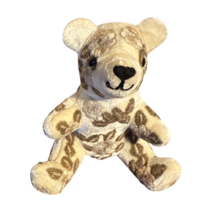 Ivory velvet bear with floral embroidery, sitting upright and smiling.