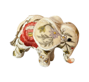 Miniature ivory velvet elephant with colorful floral embroidery and a tassel.