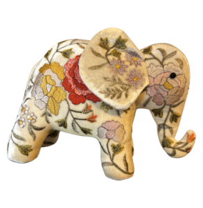 A decorative elephant figurine made of ivory silk velvet, adorned with colorful floral embroidery.