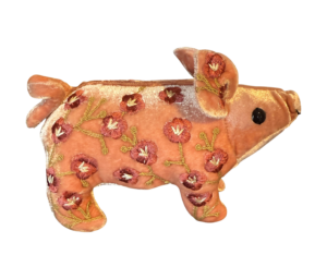 Pink velvet piglet with floral embroidery, standing on a black background.