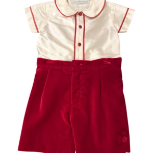 Velvet red shorts paired with a cream silk top featuring red trim and buttons.