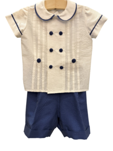 White and blue short-sleeve suit with pleats and buttons, designed for a ceremony.