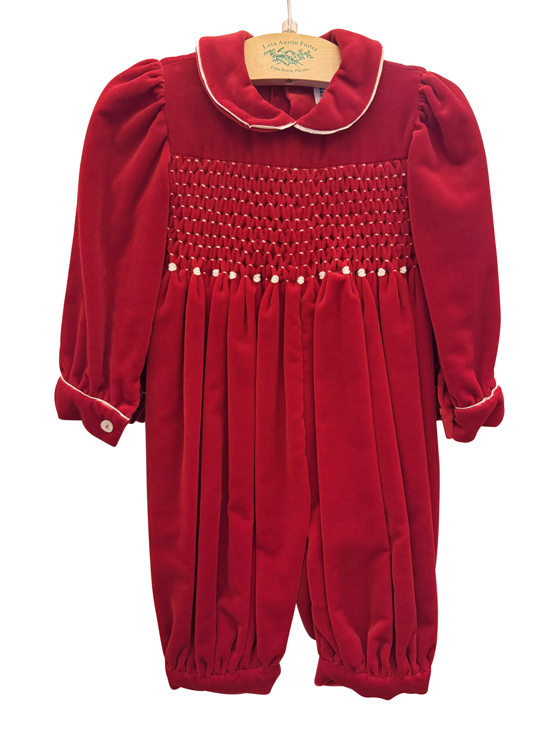 Baroni Long Smocked Velvet Romper Red velvet romper with smocked bodice, puffed sleeves, and buttoned cuffs.