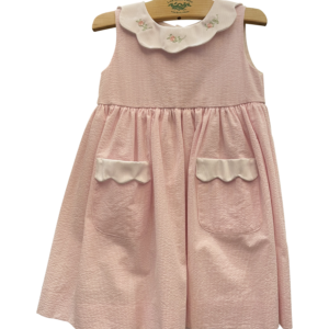 Pink and white seersucker dress with rose embroidery and scalloped collar, featuring two front pockets.