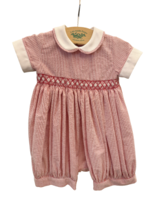 Red and white striped romper with a collar and embroidered waistband, hanging on a display.
