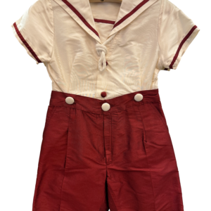 Sailor-style outfit featuring a white top with red trim and matching red shorts, displayed on a hanger.