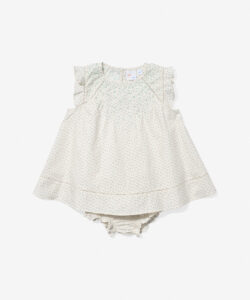 Light-colored baby dress with floral pattern and ruffled sleeves, paired with matching bloomers.