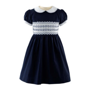 Navy blue smocked dress with puff sleeves and white collar, featuring intricate embroidery on the bodice.
