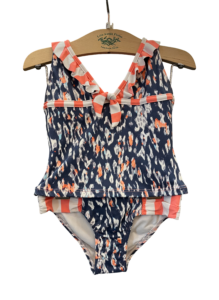 Two-piece swimsuit featuring a navy and coral pattern with ruffled straps and a tied front.