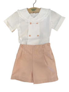 Two-piece ceremonial boys outfit featuring a white ruffled collar shirt and pink shorts.