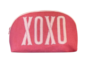 Round pink zip pouch with "XOXO" embroidered in white letters.