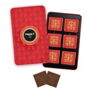 Red tin with gold design contains milk chocolate praline squares, two squares placed outside the tin.