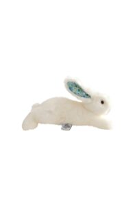 A soft, white stuffed rabbit with patterned ears, lying on its side.