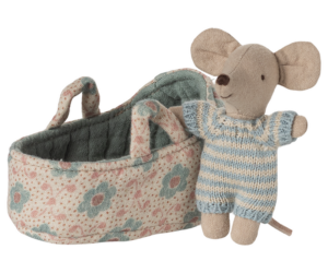 A soft toy mouse in a striped outfit stands next to a floral-patterned basket.