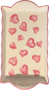 A white tray with pink heart designs scattered across its surface.